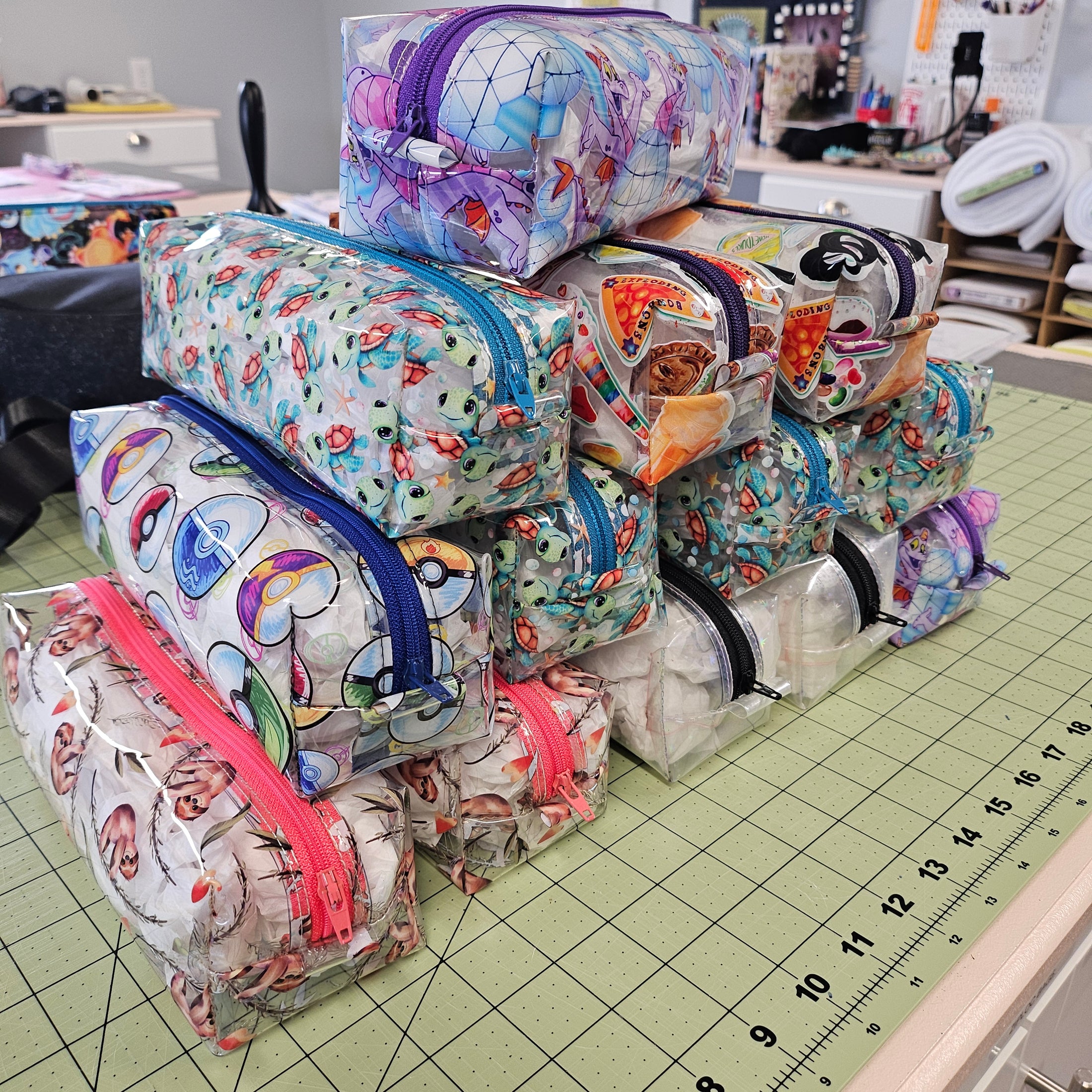 Colorful fabric bags with zippers on a cutting mat