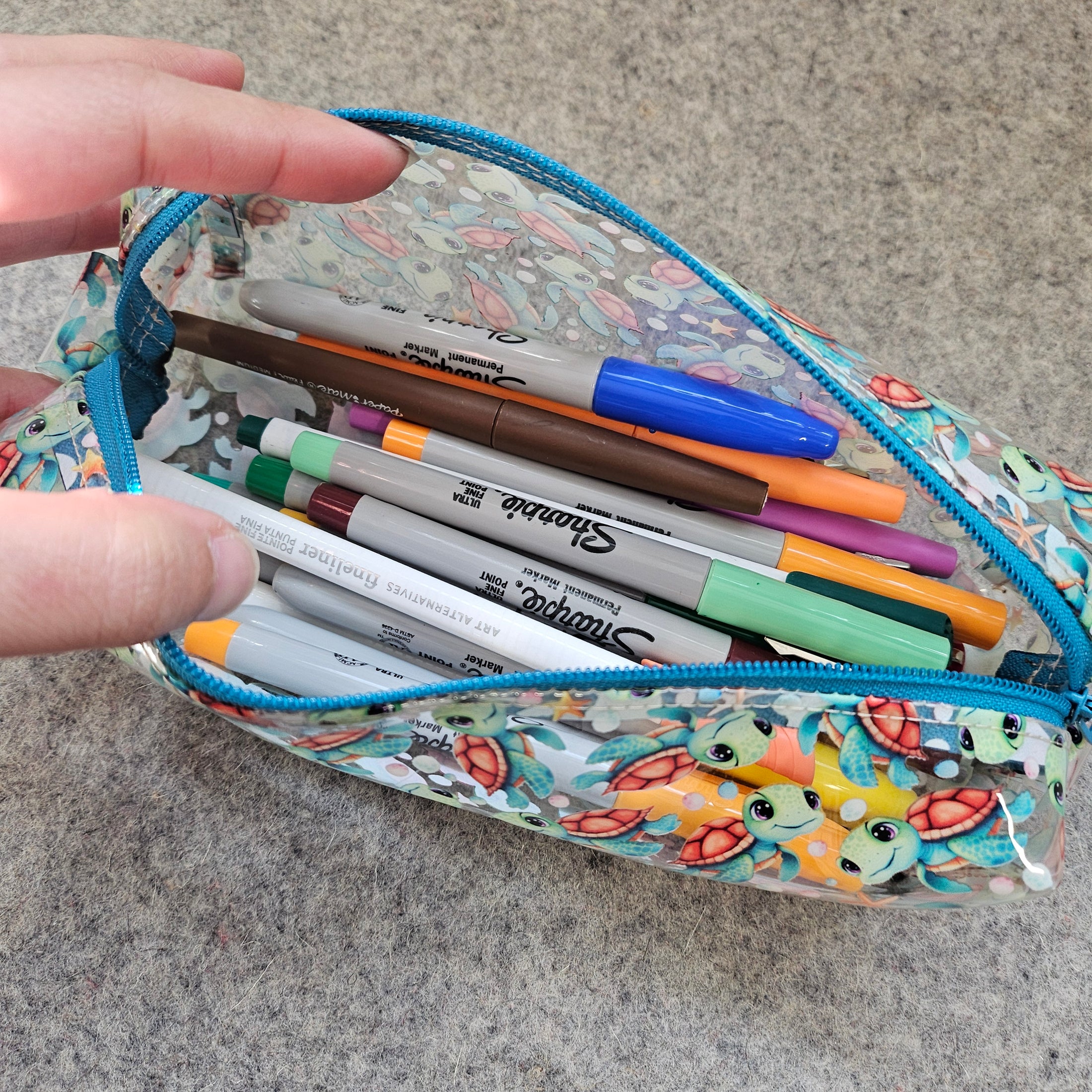 Colorful pencil case with pens and markers on a textured surface