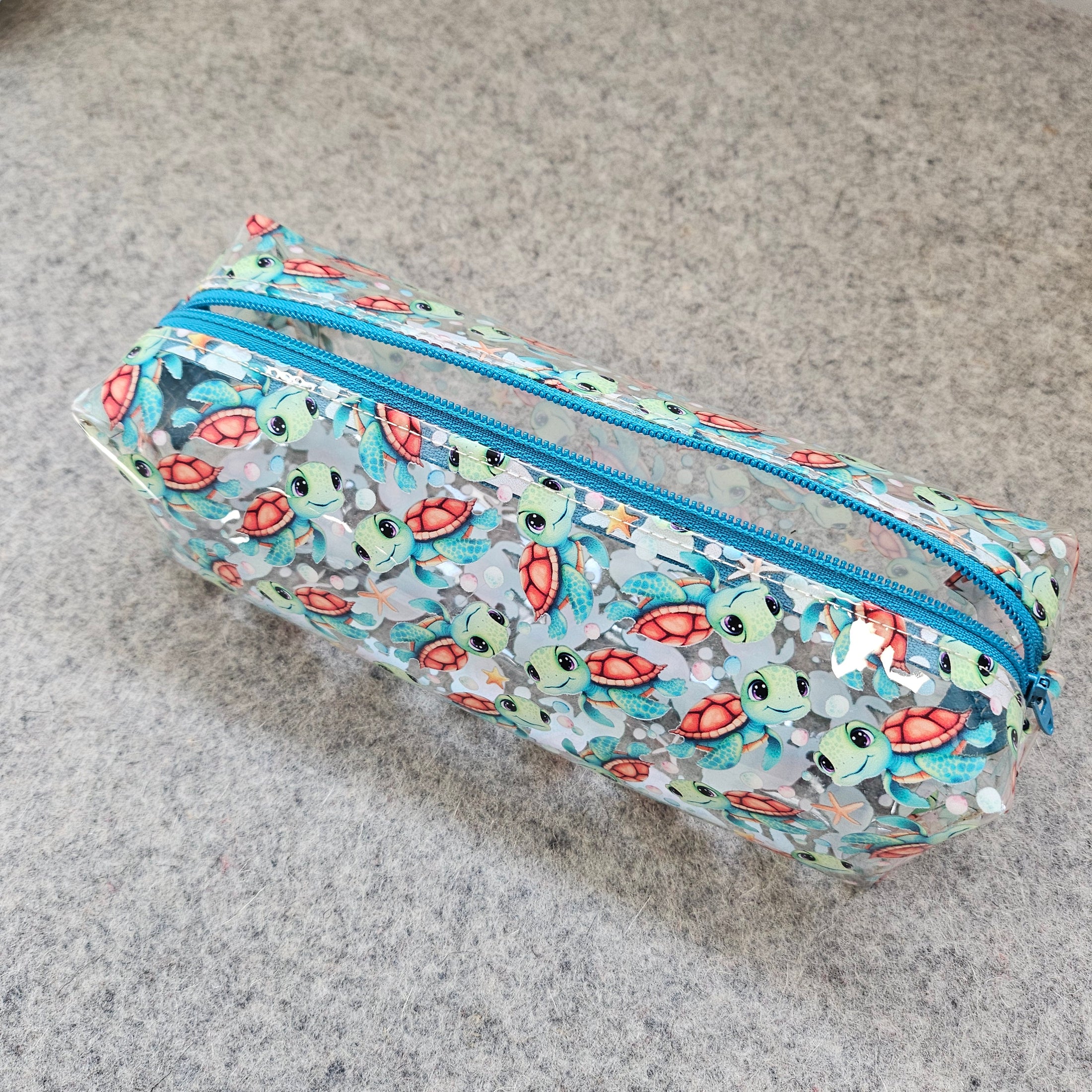 Pencil case with turtle pattern on a gray surface