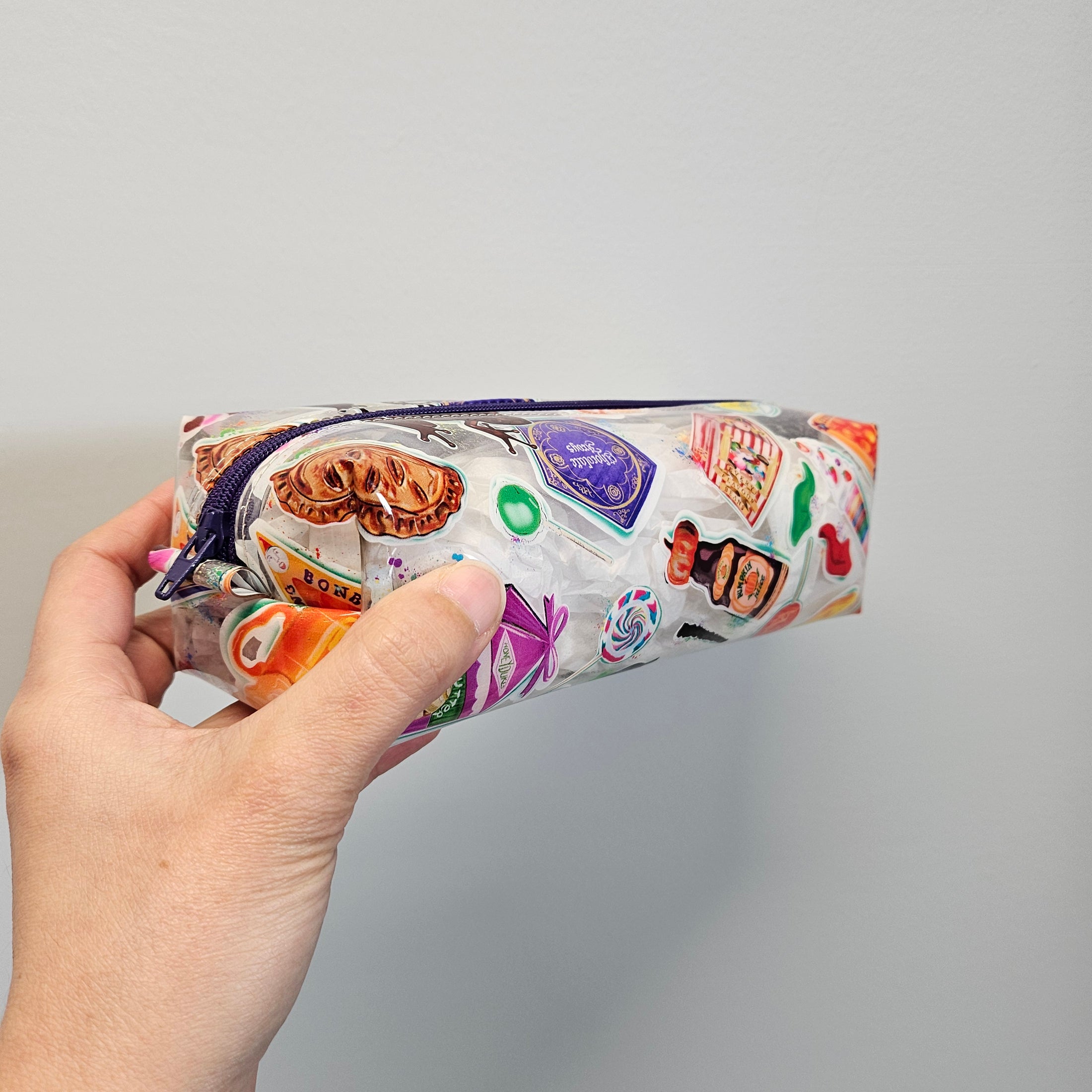 Hand holding a colorful product packaging against a gray background