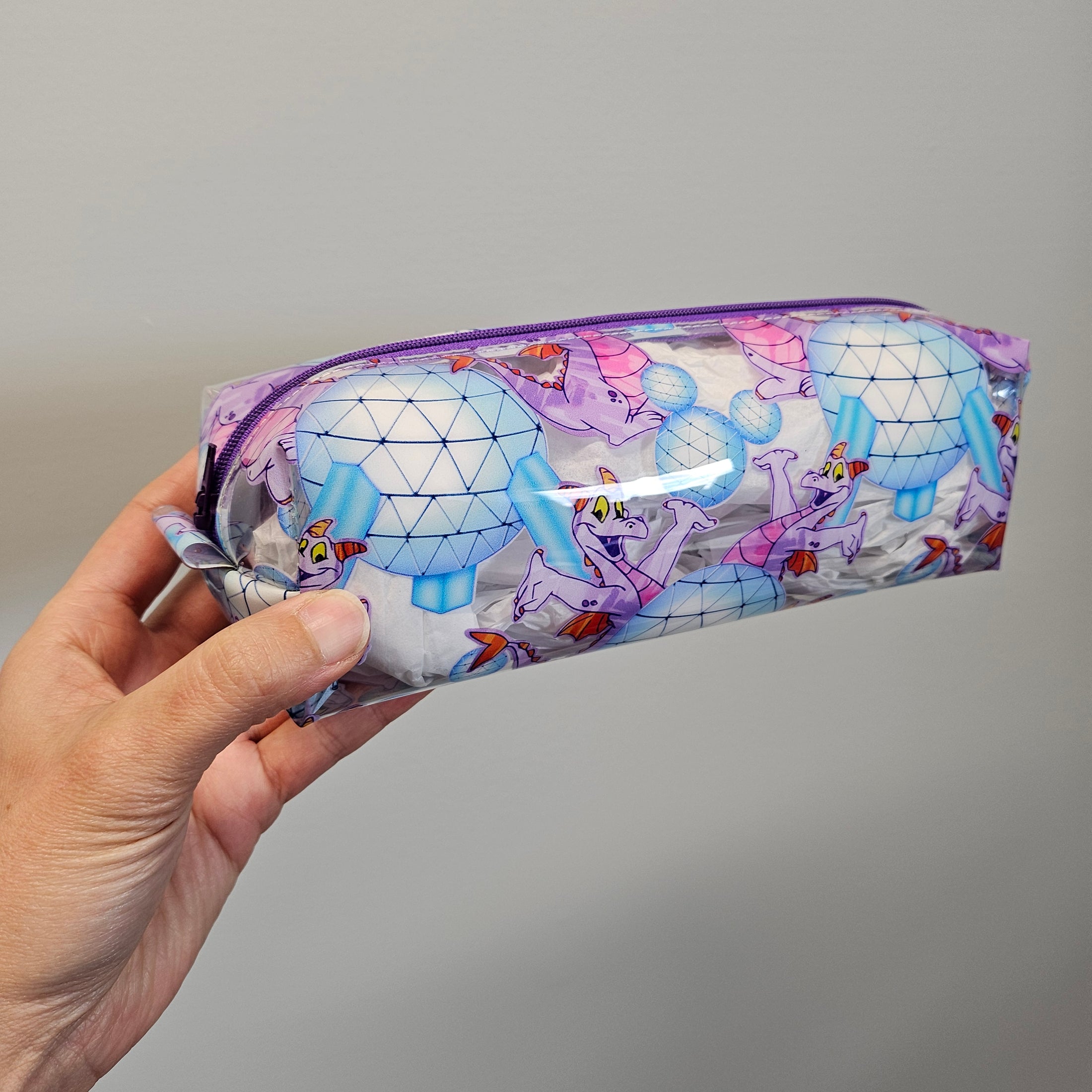 Hand holding a colorful patterned product against a plain background