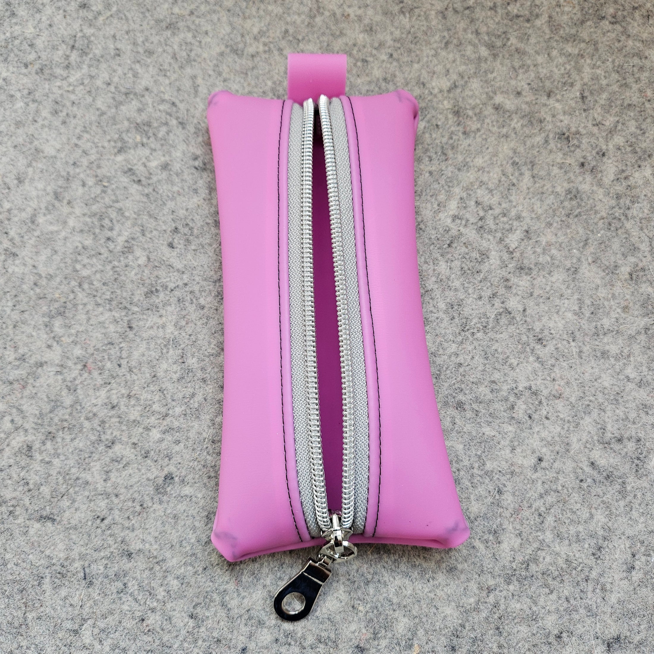 Pink pouch with a zipper on a gray textured background