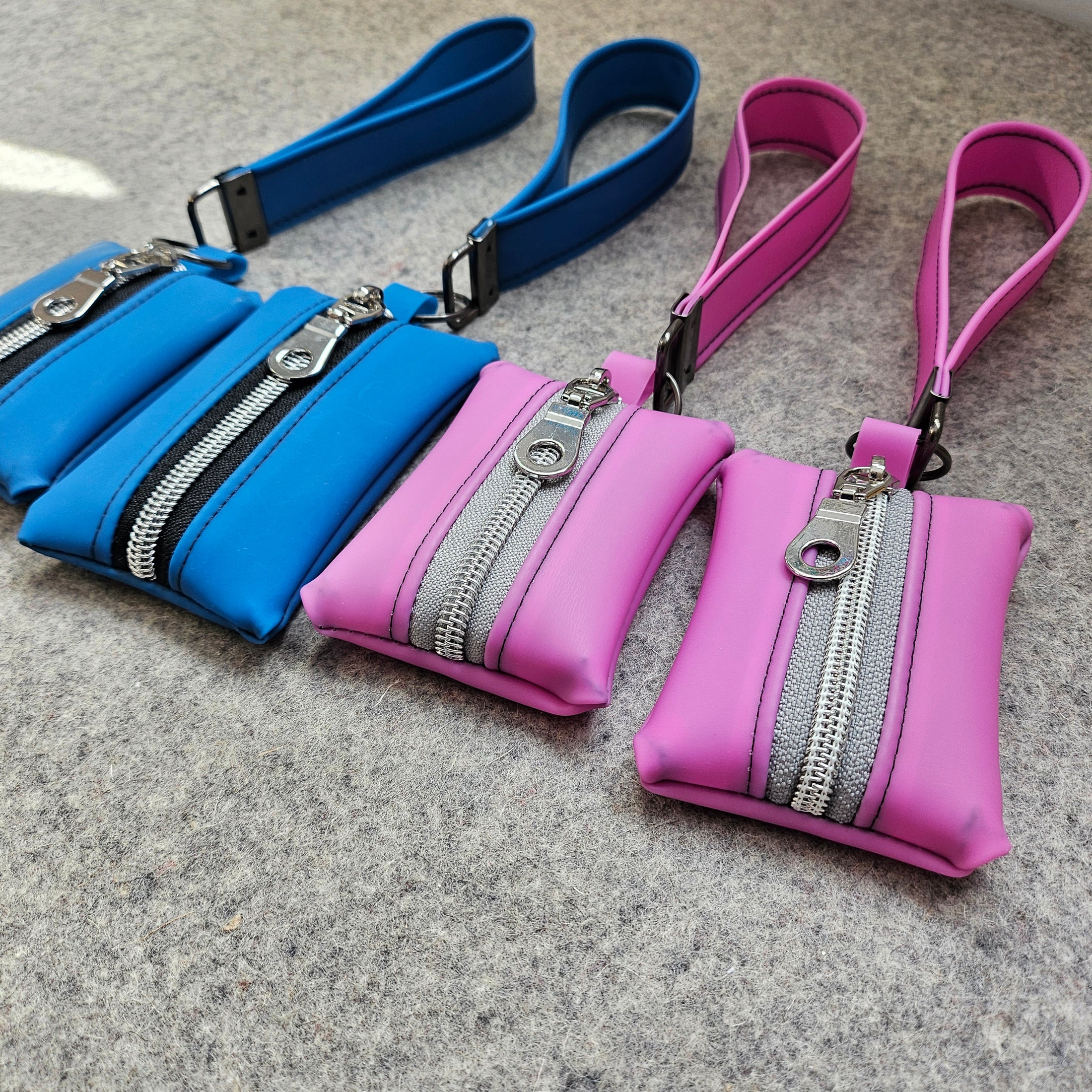 Pink and blue bags with zippers on a gray surface