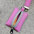 Load image into Gallery viewer, Pink keychain pouch with a visible brand logo on a gray surface
