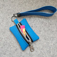 Load image into Gallery viewer, Blue keychain pouch with wrist strap and Burts Bees lip balm on a gray surface
