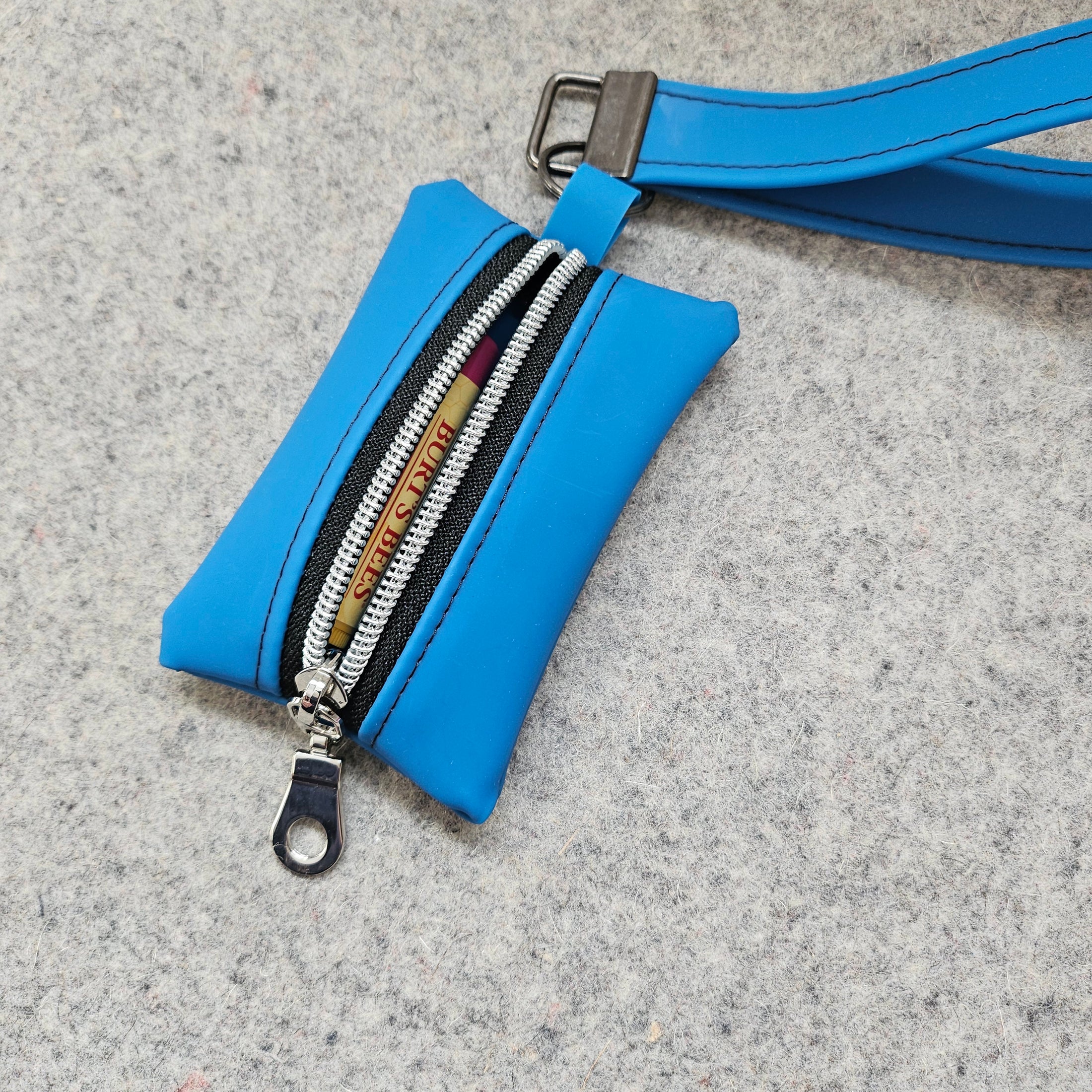 Blue wallet with a strap on a gray surface
