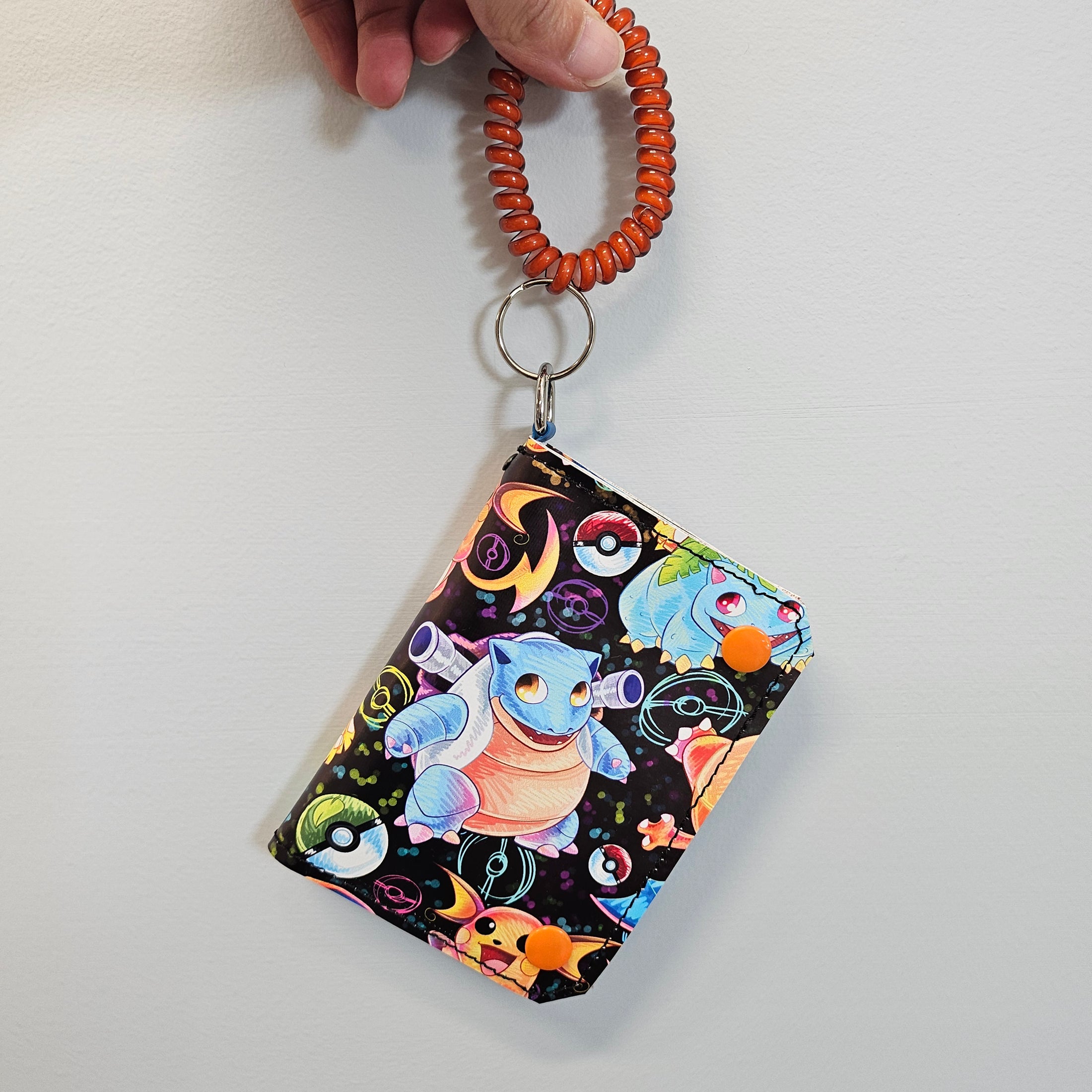 Pokemon bifold wallet held against a light gray surface.