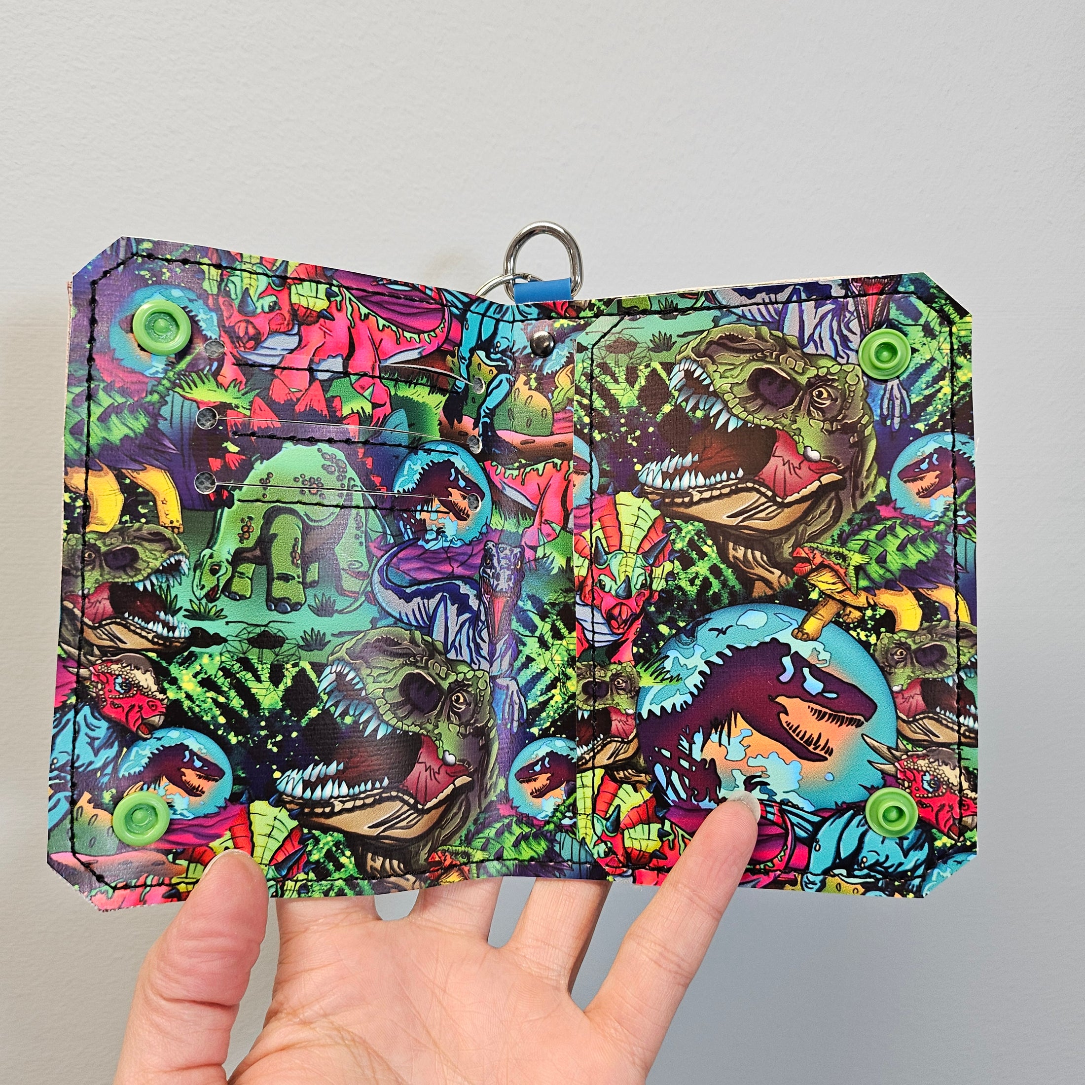 Colorful patterned pouch held by a hand on a gray background