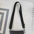 Load image into Gallery viewer, Black strap with a clip on a grid surface
