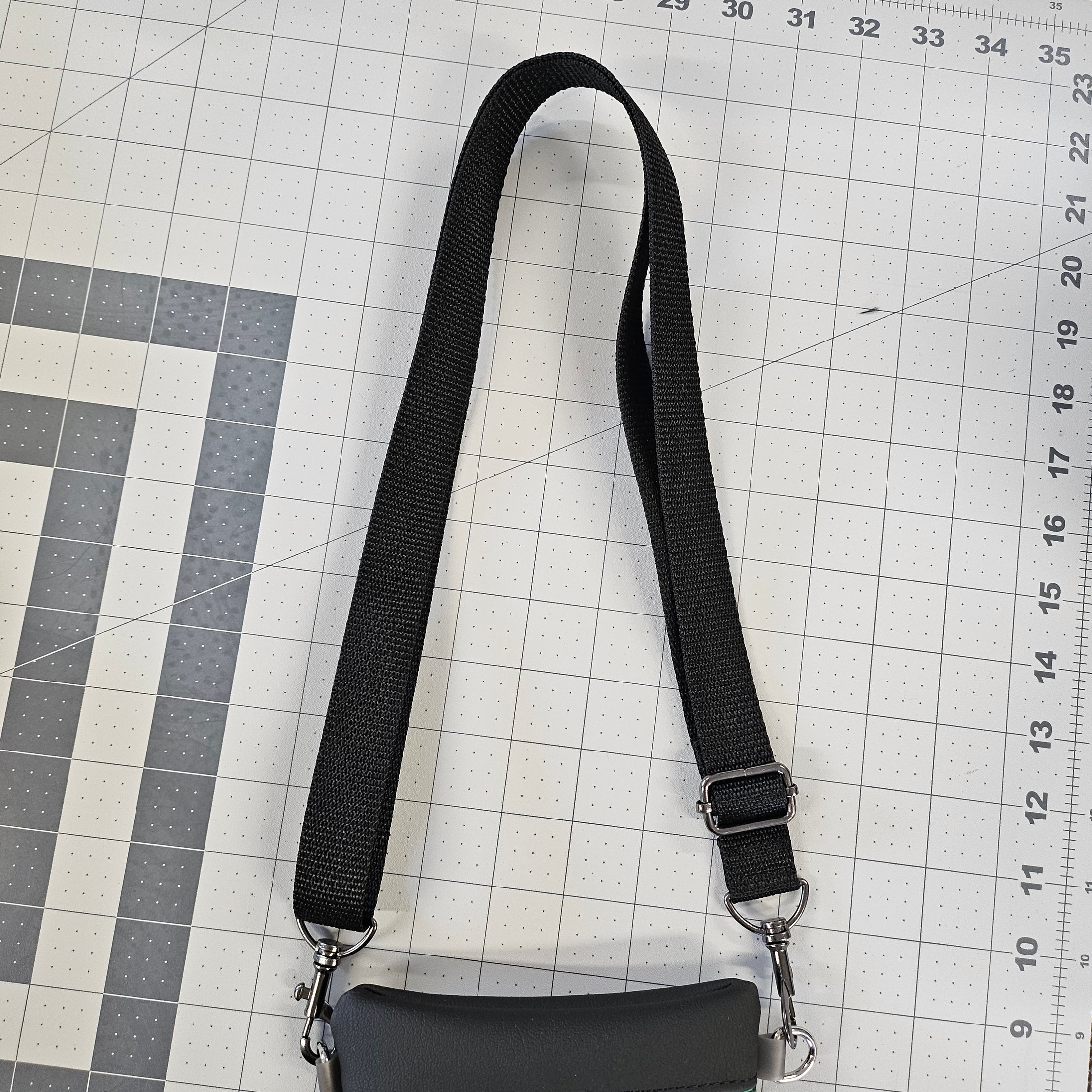 Black strap with a clip on a grid surface