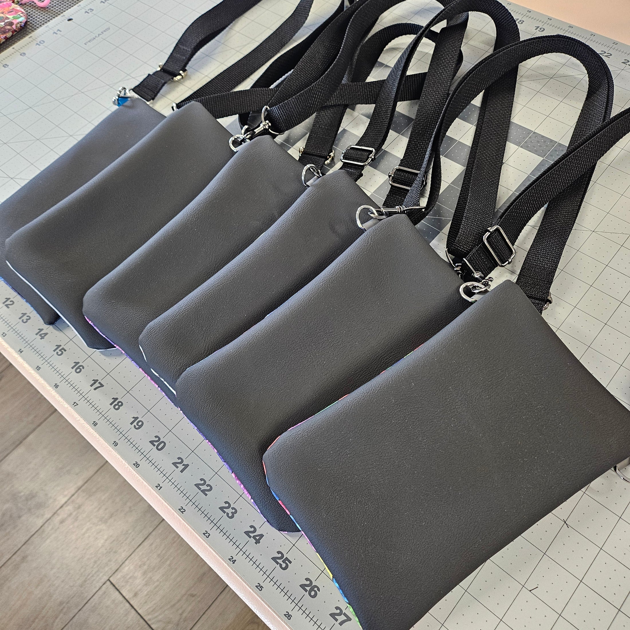 Set of gray bags with black straps on a checkered surface