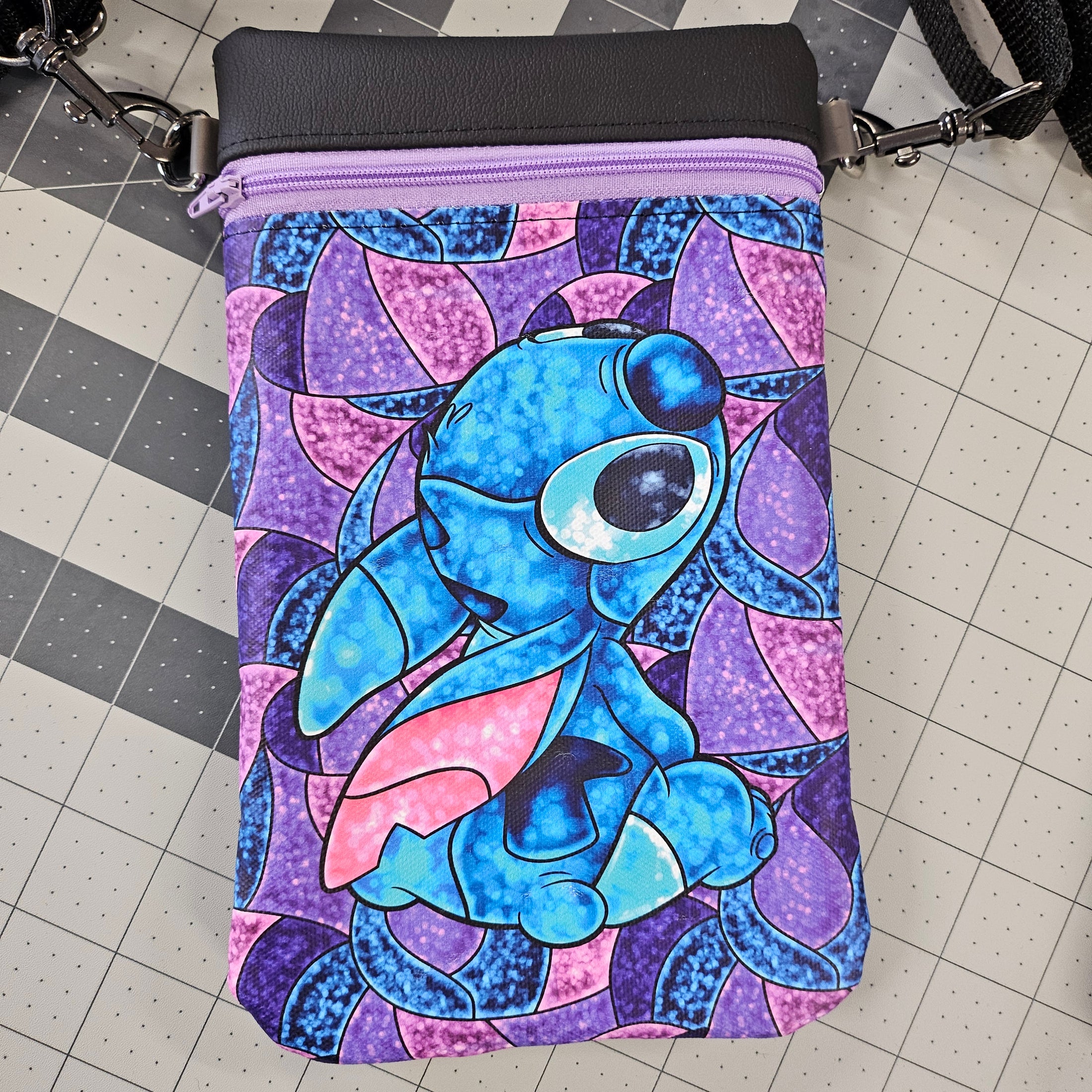Blue cartoon character on a purple and pink patterned bag on a grid background