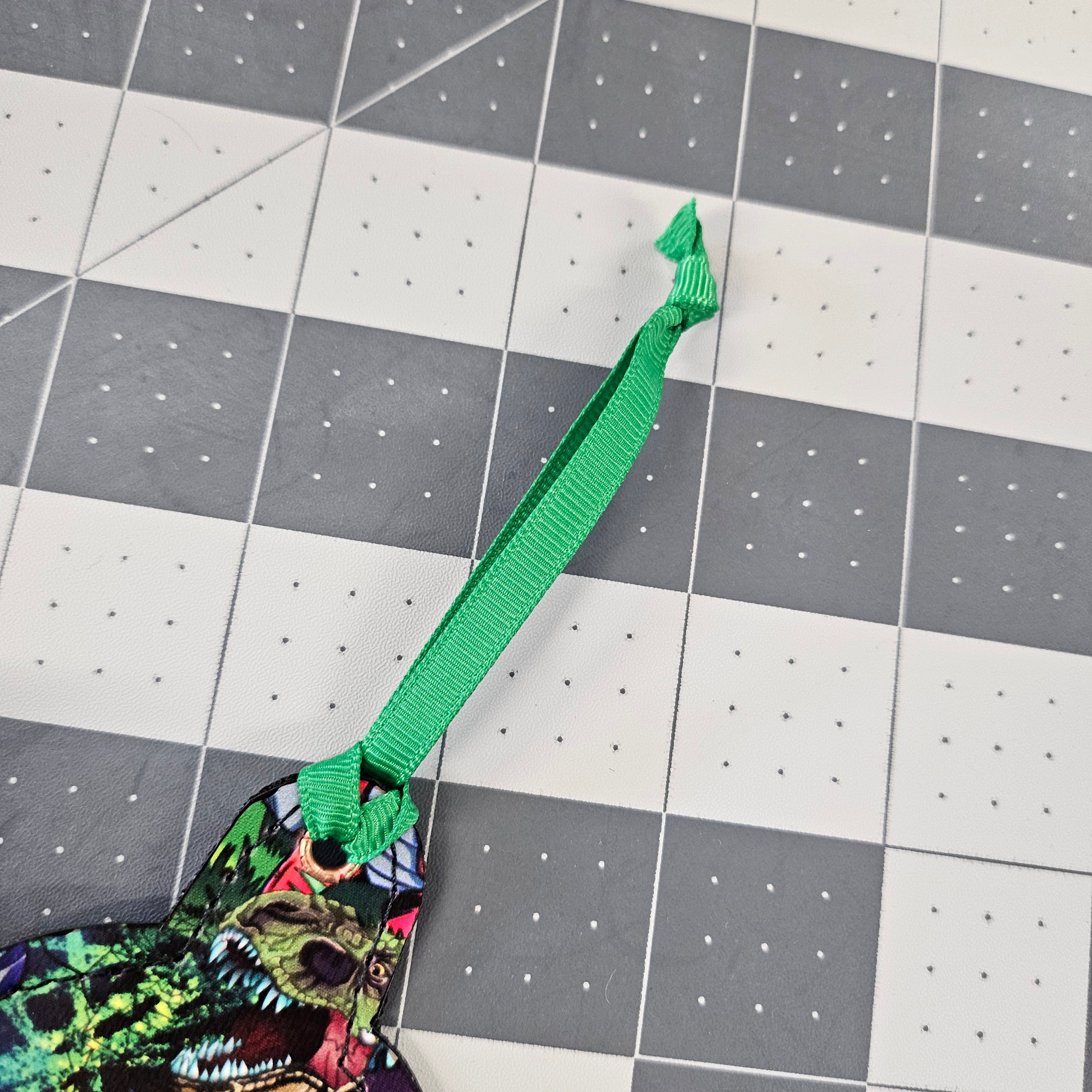 Green ribbon with a knot on a grid like surface.