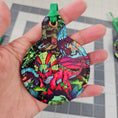Load image into Gallery viewer, Triceratops ornament held by hand.
