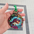 Load image into Gallery viewer, Hand holding a t rex ornament.
