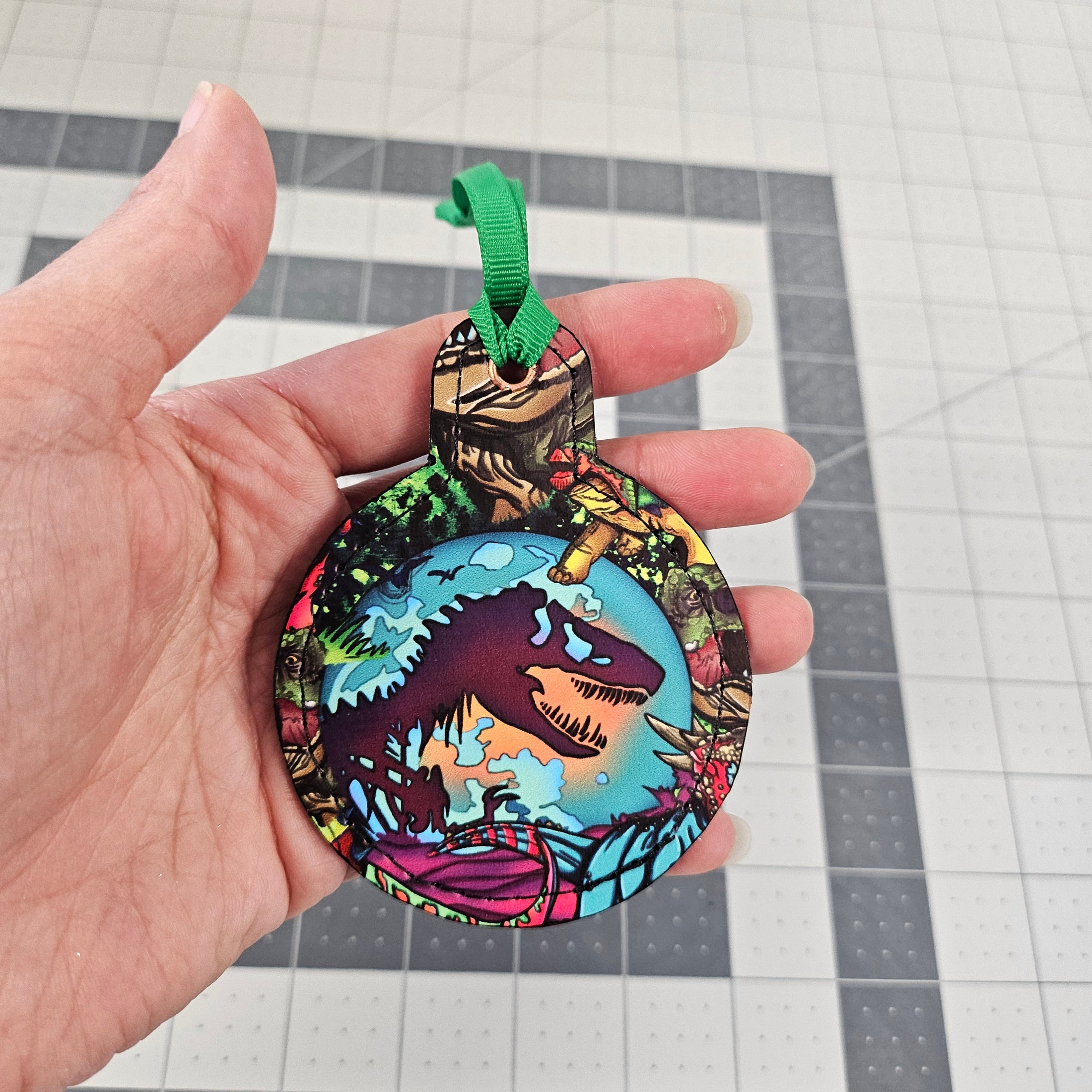 Hand holding a t rex ornament.