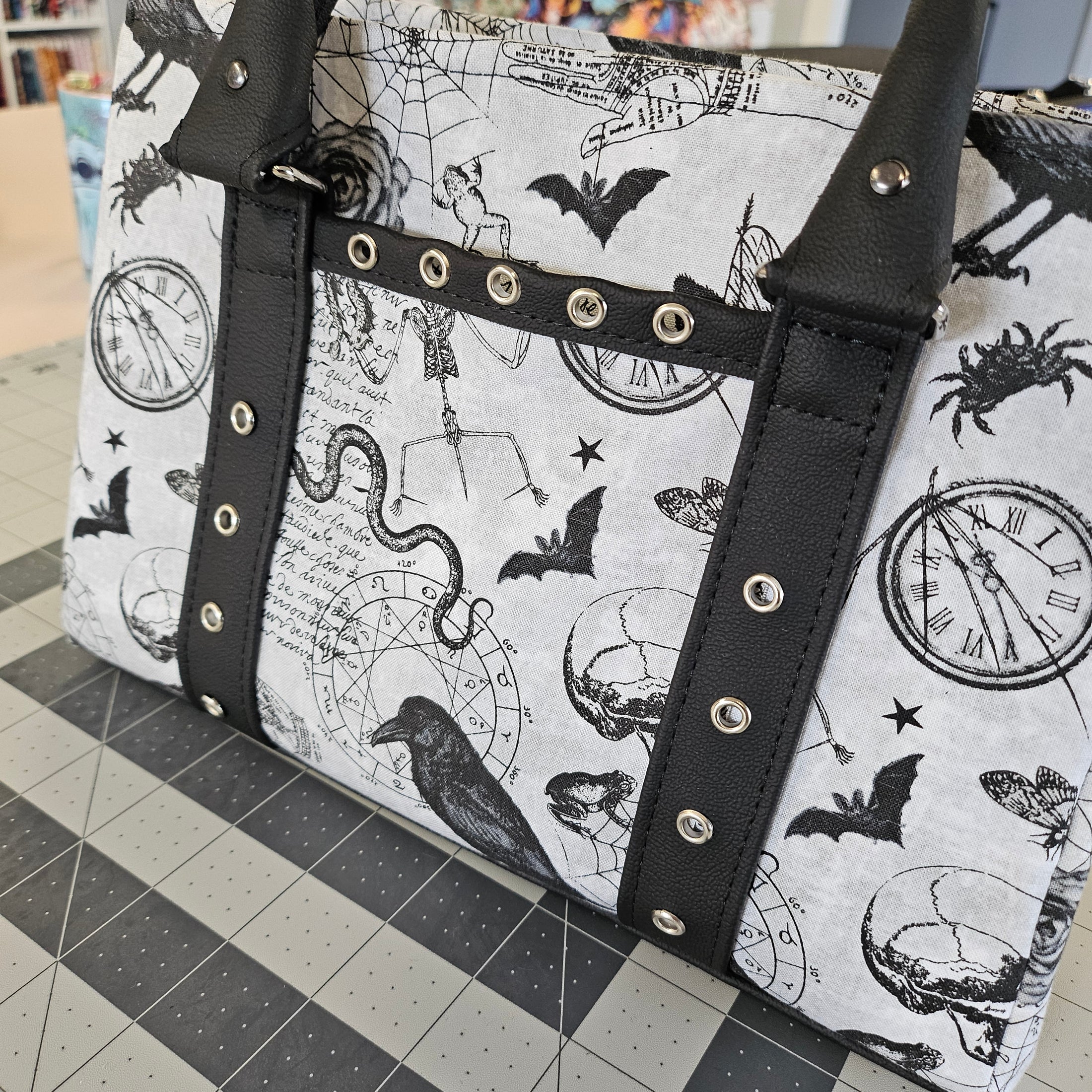 Bag with zodiac pattern and black straps on a checkered floor