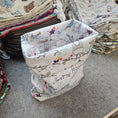 Load image into Gallery viewer, Stack of patterned fabric on a gray surface
