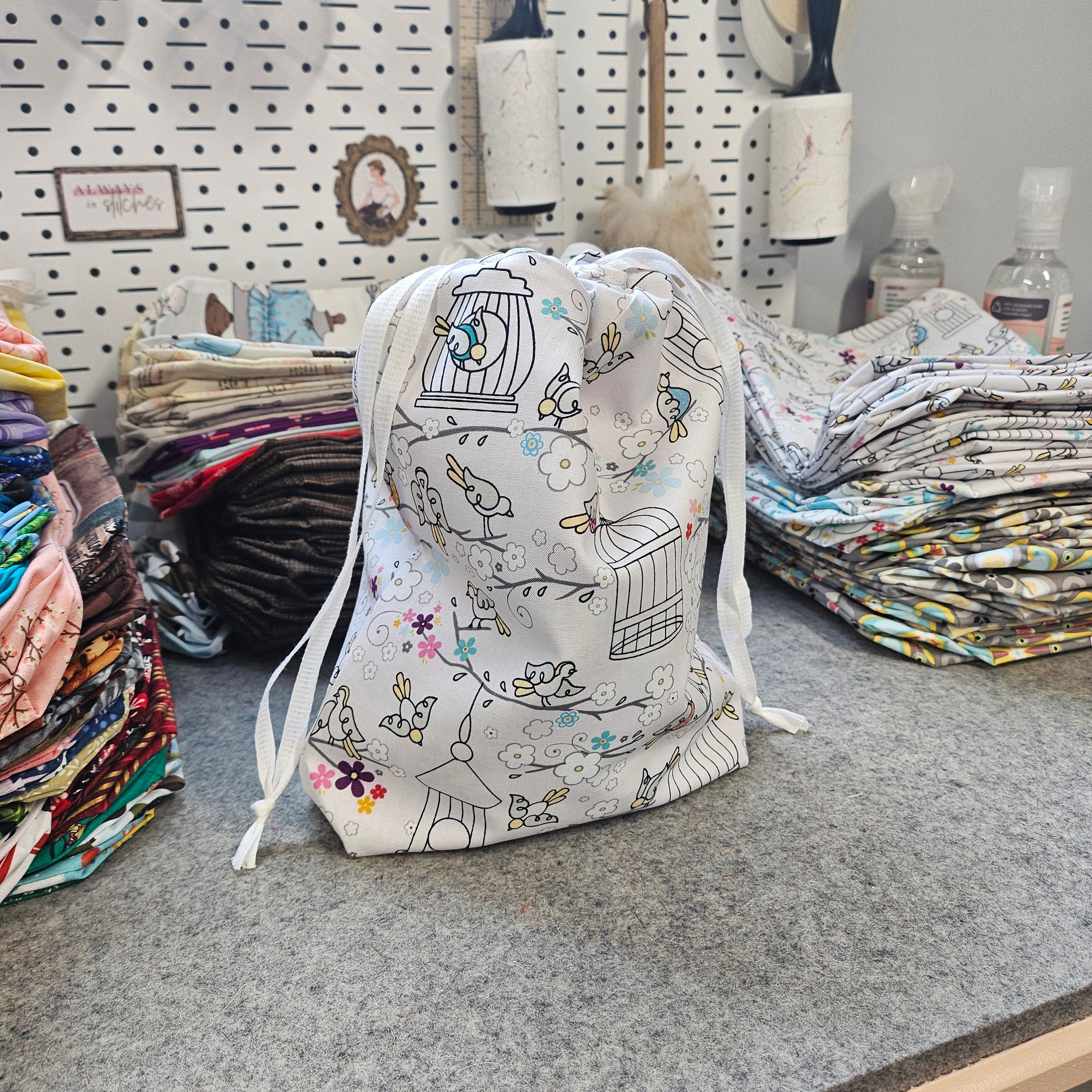 Lots of reusable drawstring gift bags on a gray surface.