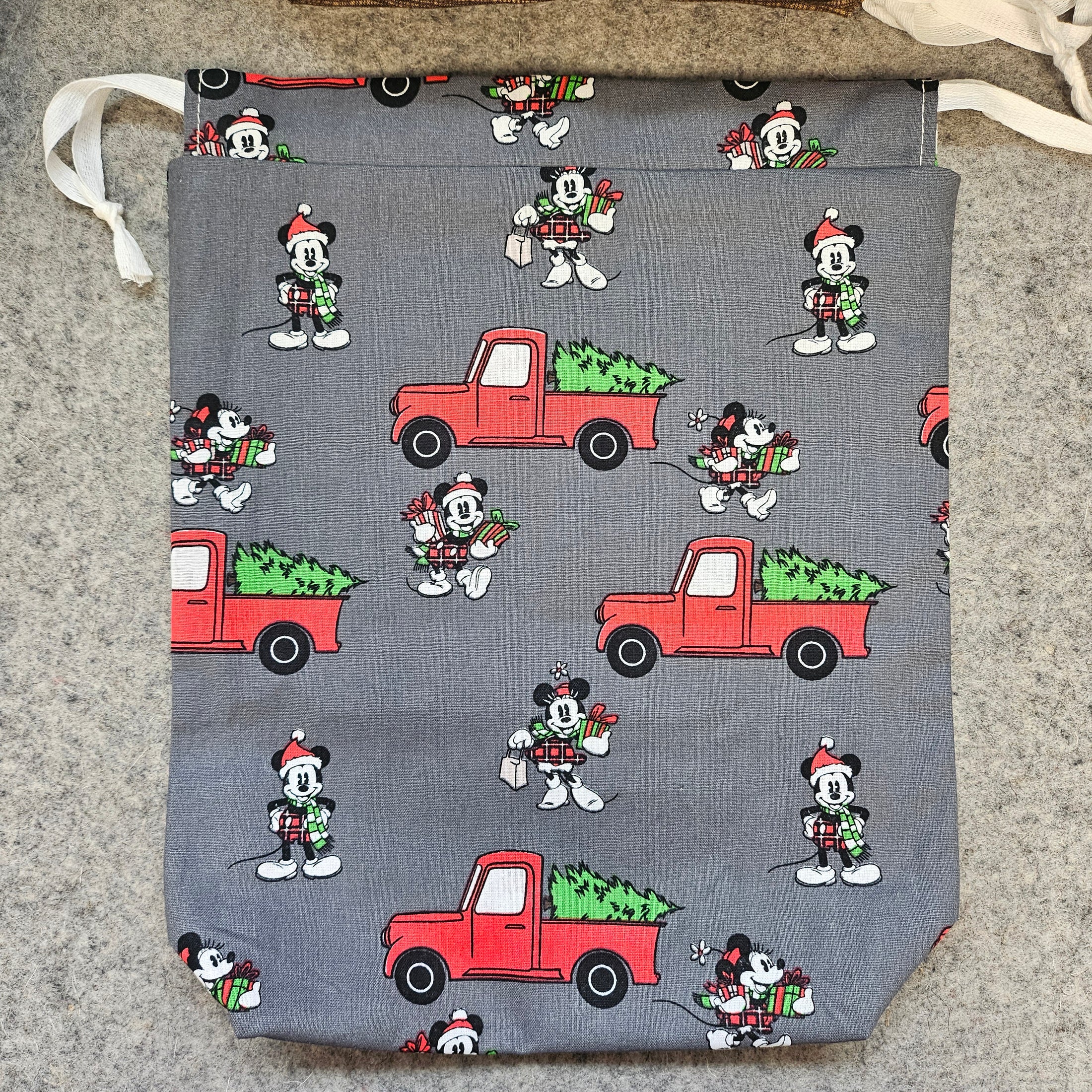 Gray fabric with red trucks and black and white characters on a textured surface
