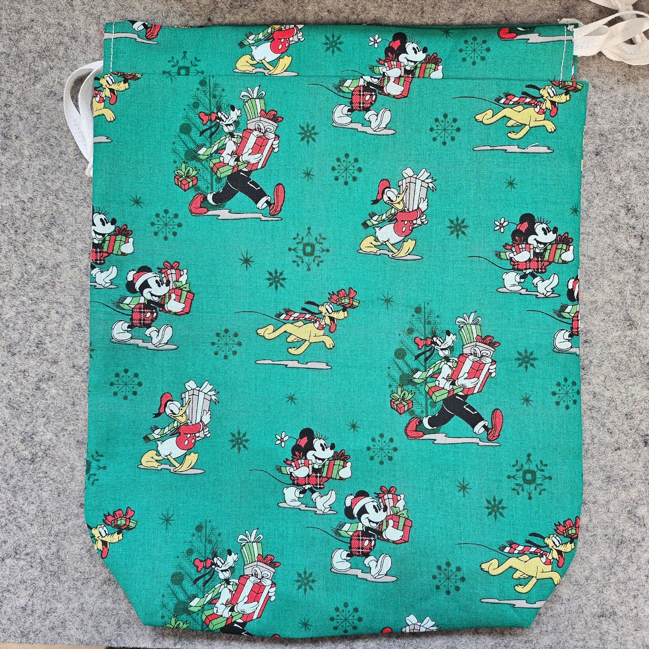 Teal fabric with cartoon character pattern on a gray surface