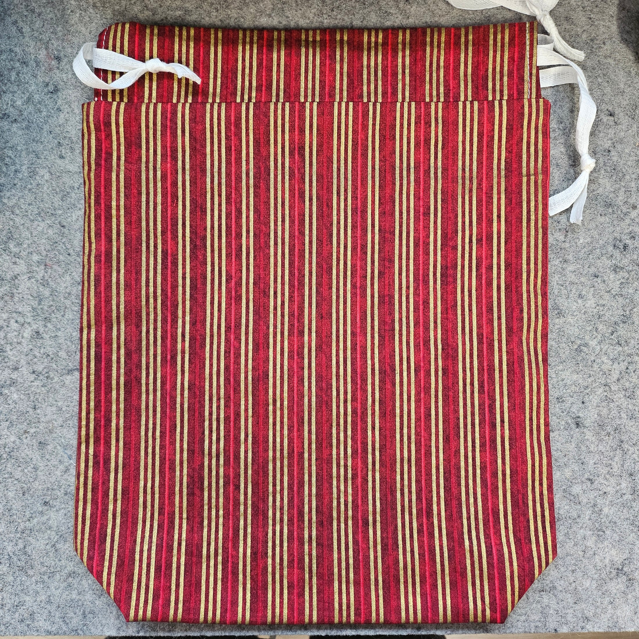Red and beige striped mat with white straps on a gray surface