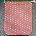 Load image into Gallery viewer, Peach colored drawstring bag with white x's.
