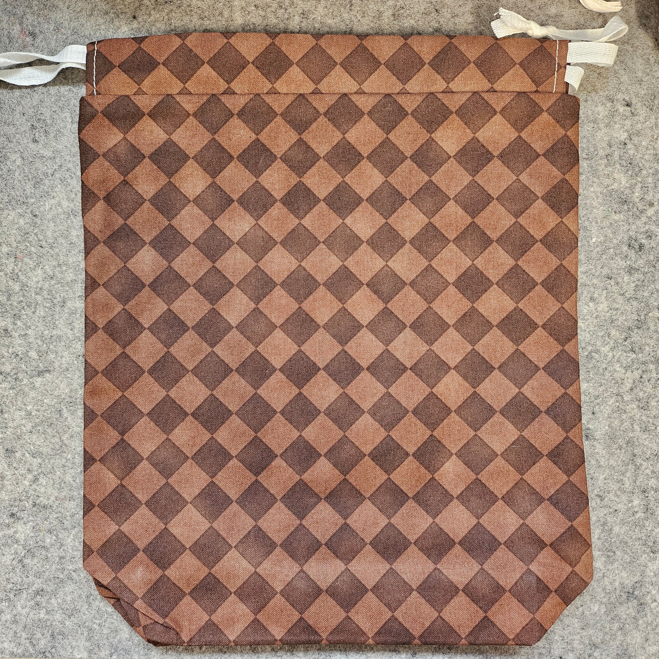 Brown and beige checkered mat on a concrete floor