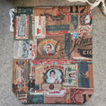 Load image into Gallery viewer, Decorative fabric with vintage-style collage pattern on a textured surface
