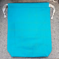 Load image into Gallery viewer, Blue fabric bag with white drawstrings on a gray surface
