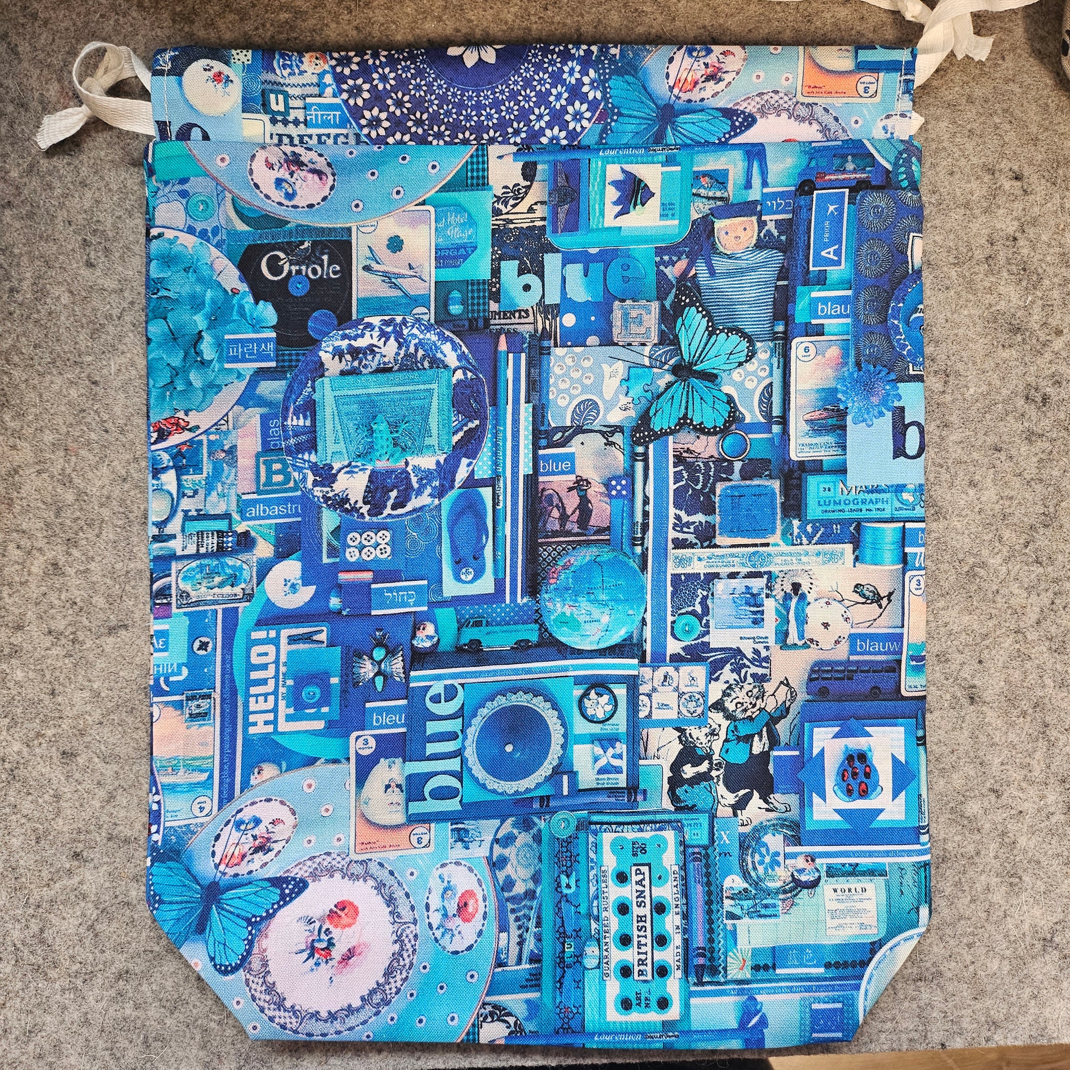 Blue themed drawstring bag on a gray surface.