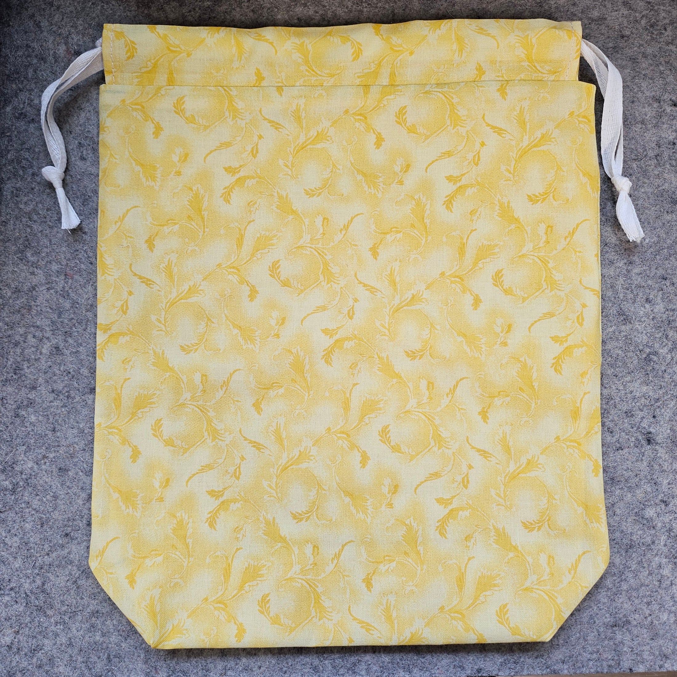 Yellow fabric bag with a subtle pattern on a gray background