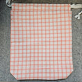 Load image into Gallery viewer, Plaid fabric with red and white pattern on a gray surface
