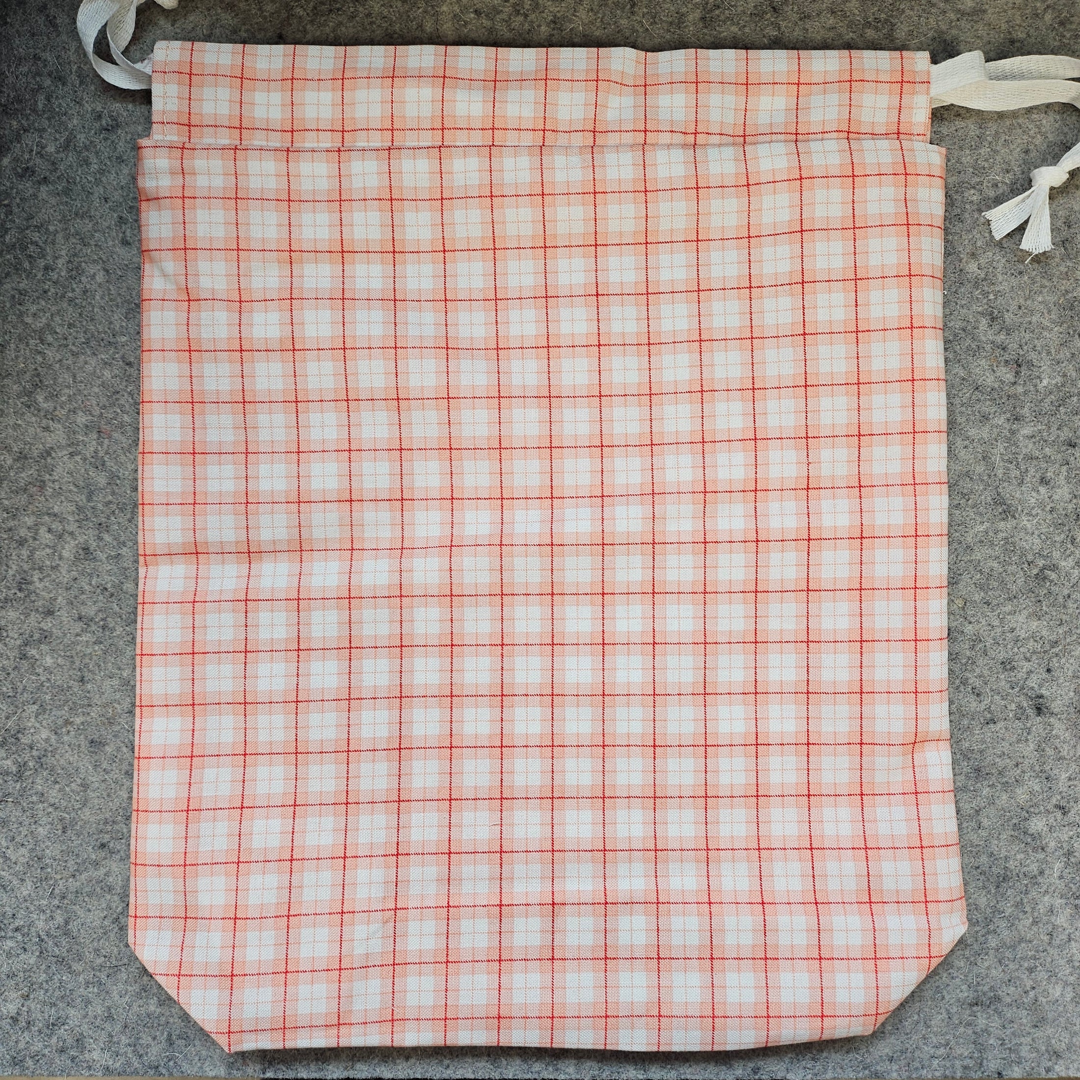 Plaid fabric with red and white pattern on a gray surface
