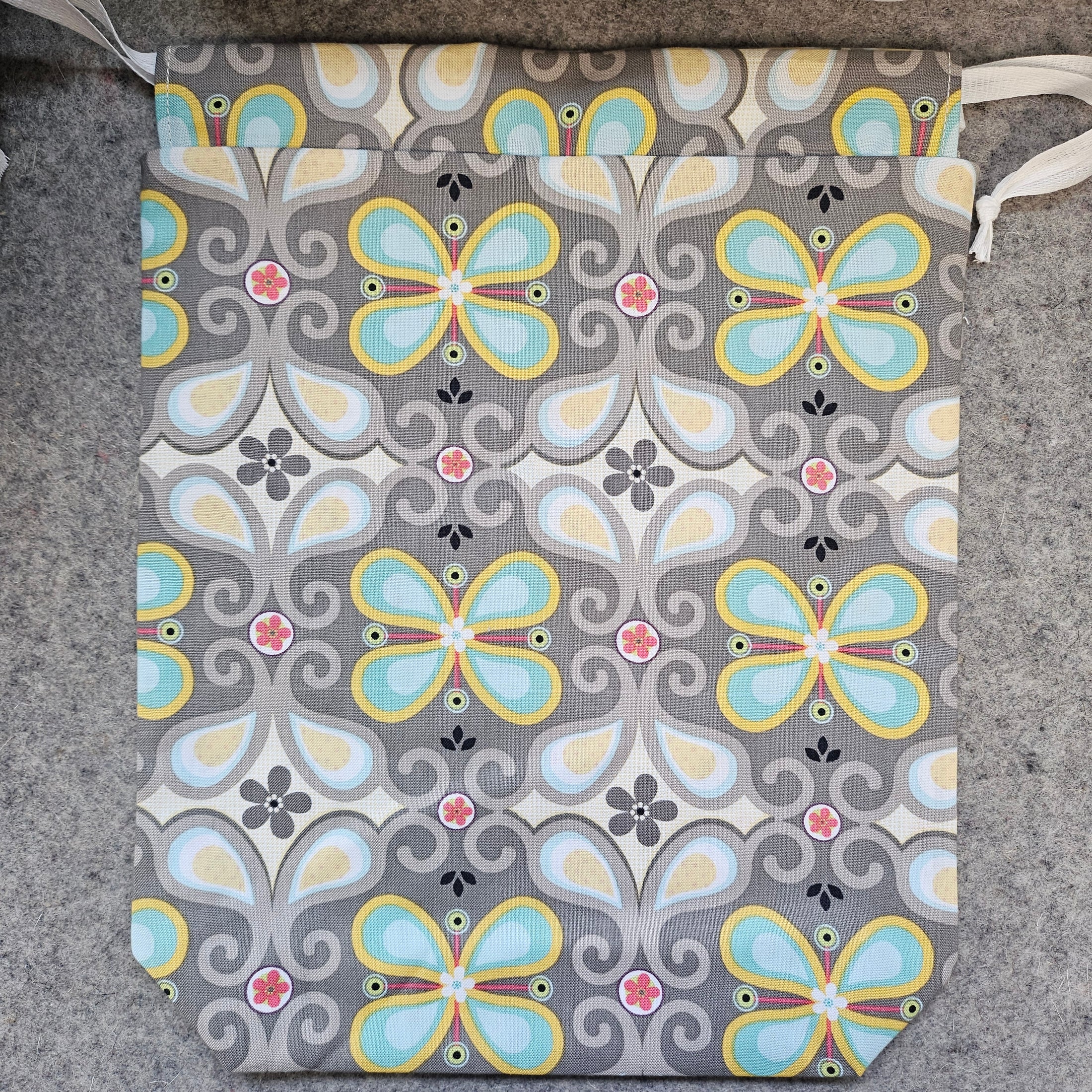 Patterned pouch with butterfly design on a gray surface