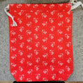 Load image into Gallery viewer, Red fabric with white patterns on a gray surface

