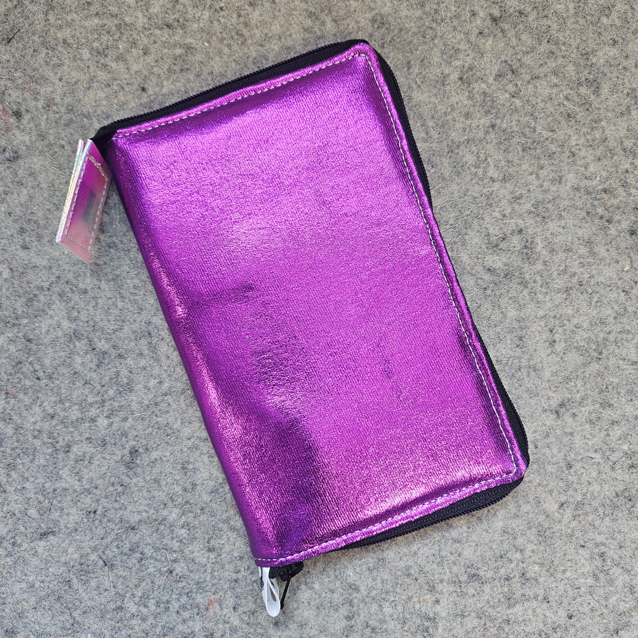Purple metallic wallet on a gray concrete surface