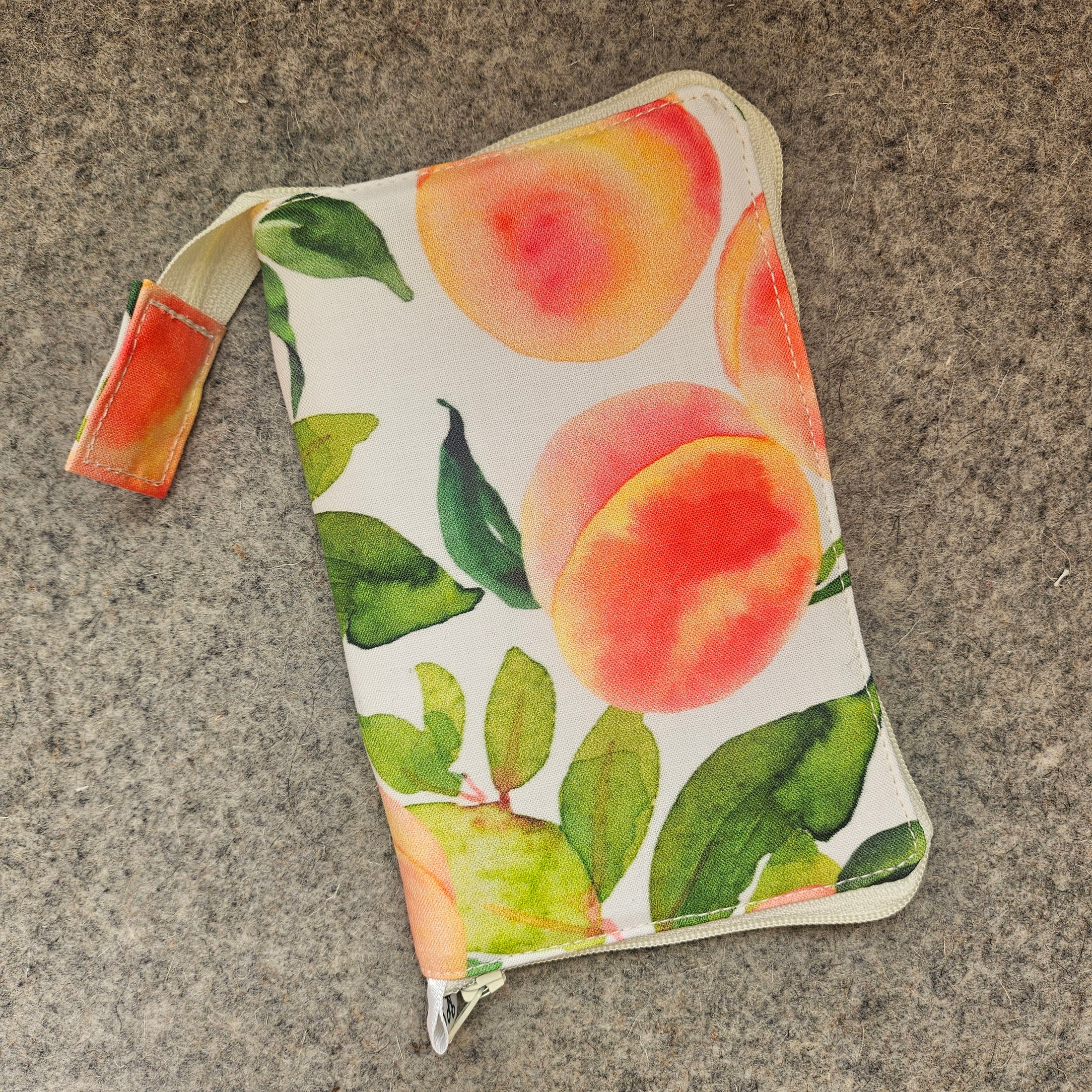 Small pouch with peach and leaf pattern on a textured surface