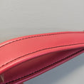 Load image into Gallery viewer, Close-up of a red leather product with visible stitching on a light gray background
