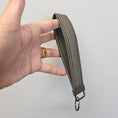 Load image into Gallery viewer, Hand holding a green belt strap against a light gray background
