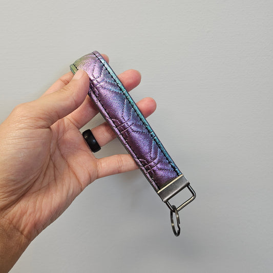 Shimmery metallic gradient faux leather key fob.