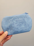 Load image into Gallery viewer, A light blue fabric zippered pouch with a dark blue line-art graphic of a slot machine and the text 'FRESH BREAD' on the front, held by a hand against a plain light gray background.

