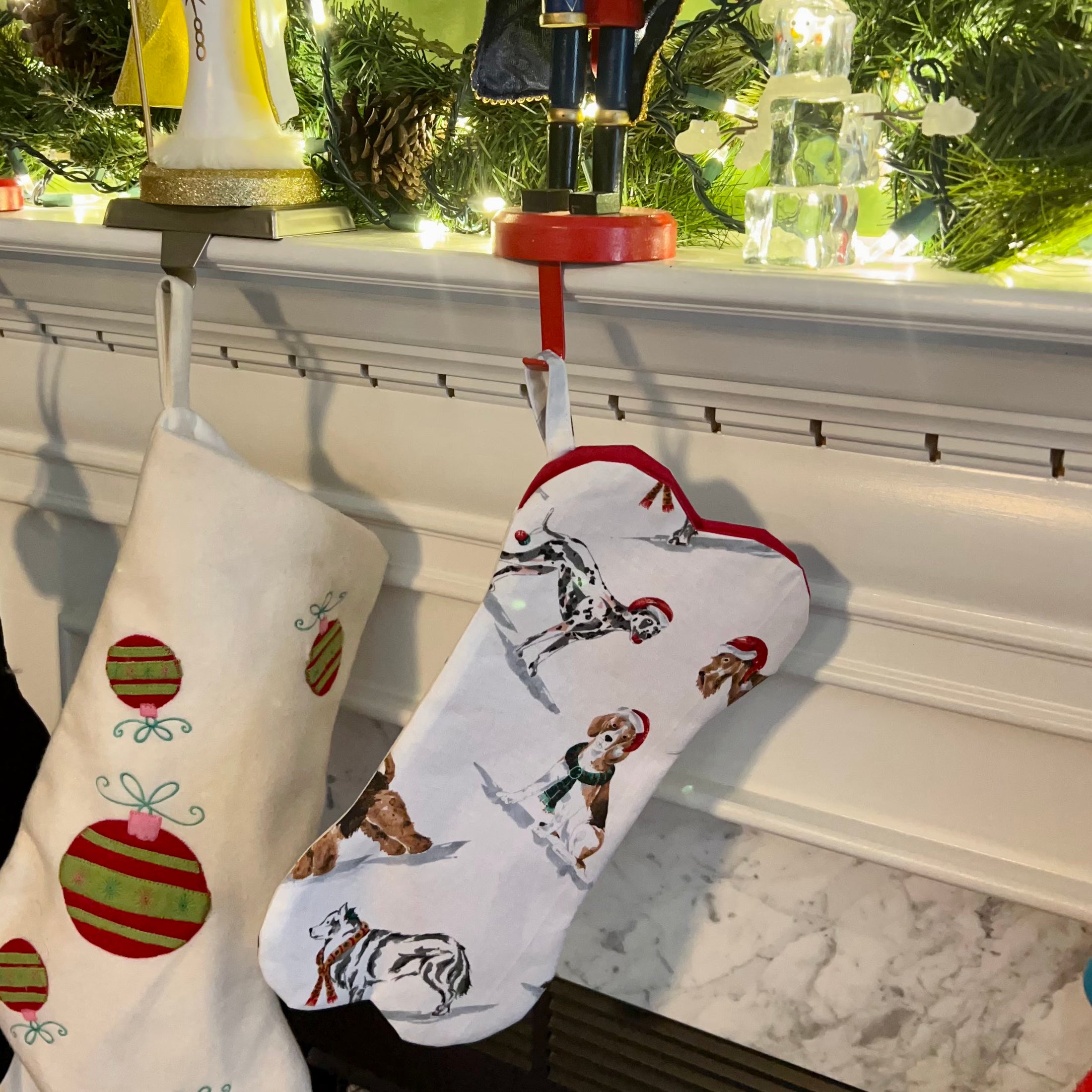 Bone shaped Christmas stocking for dogs hanging on a mantle.