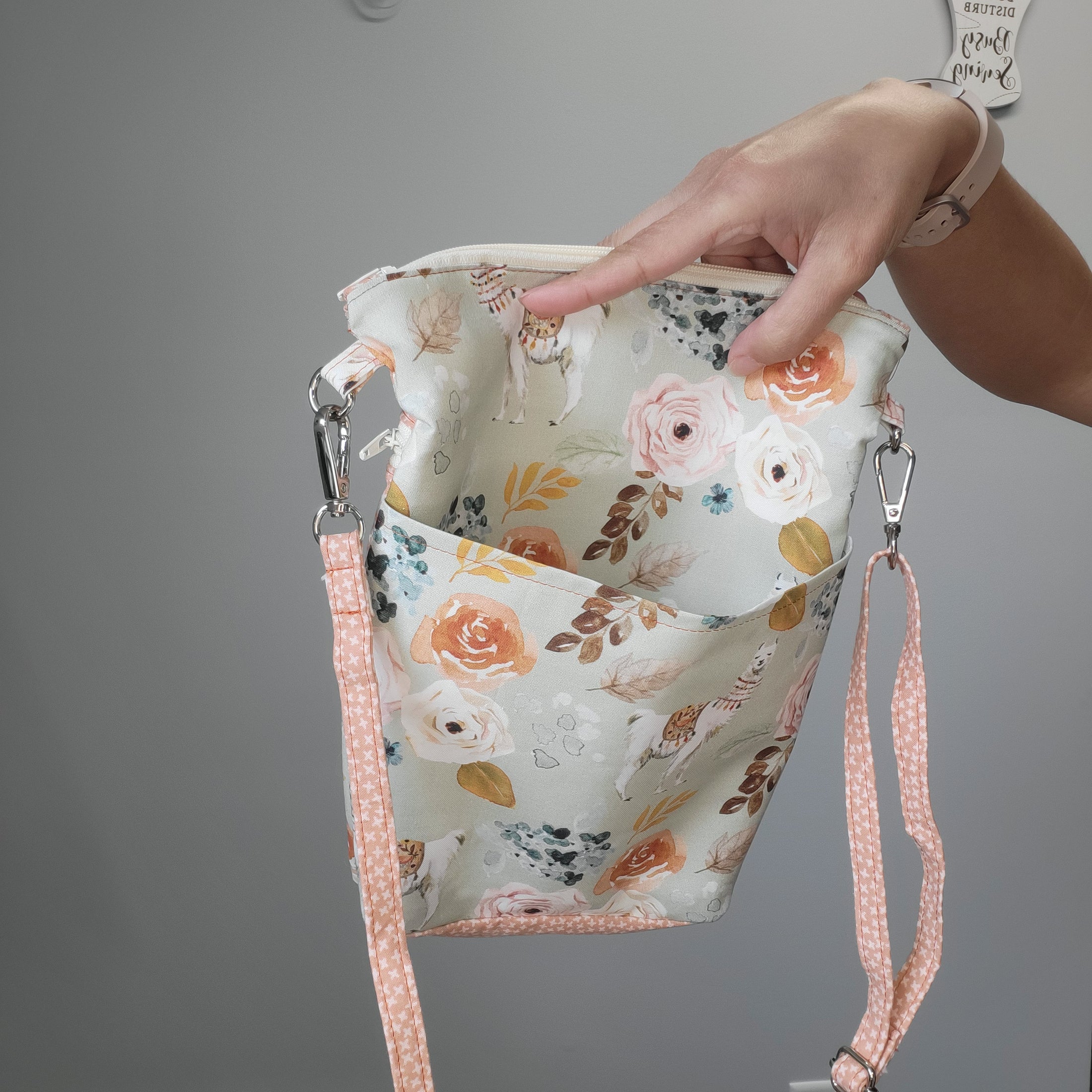 Floral llama shoulder purse with multiple zippers. 