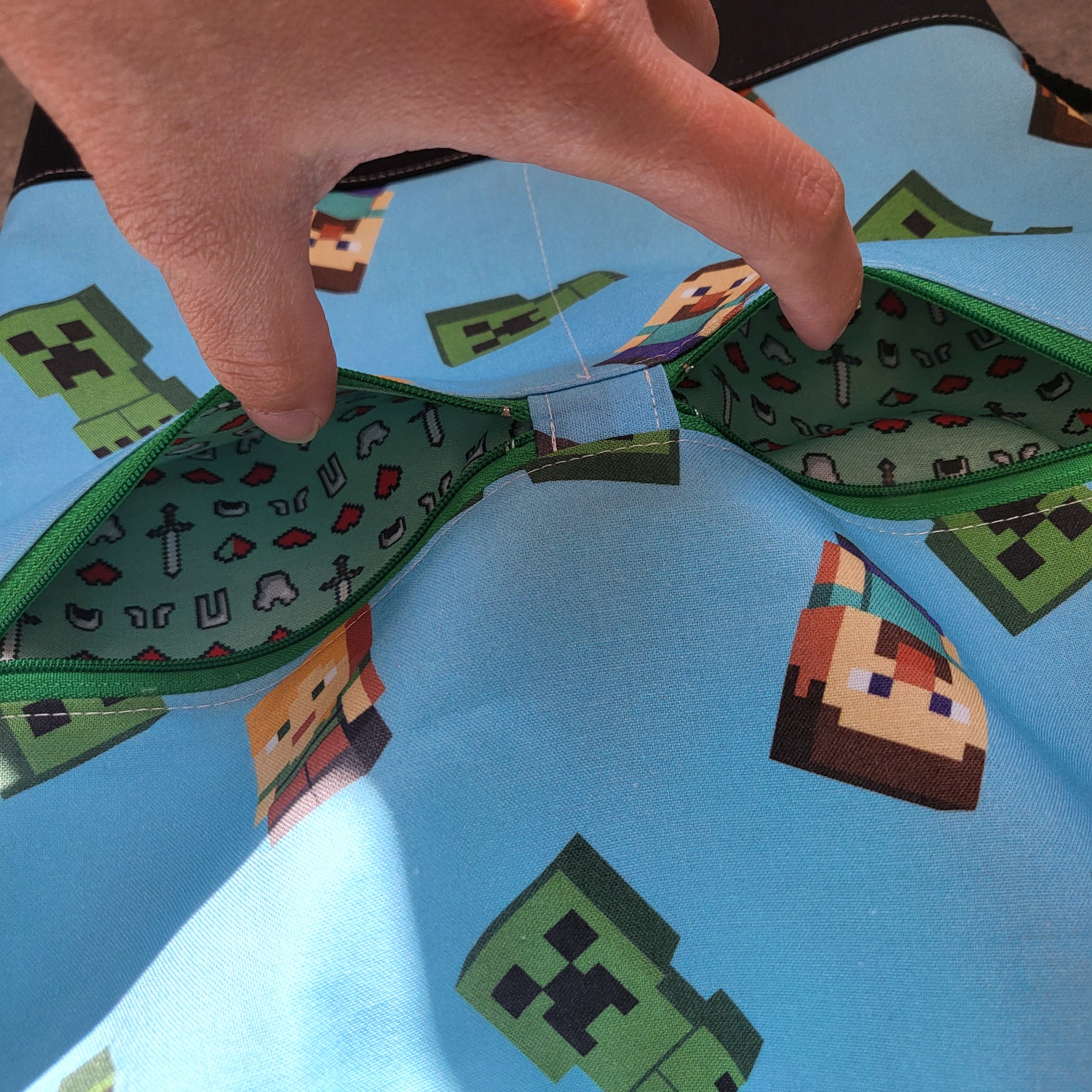 Inside of the Minecraft exterior pockets showing Zelda inspired fabric with hearts and swords. 