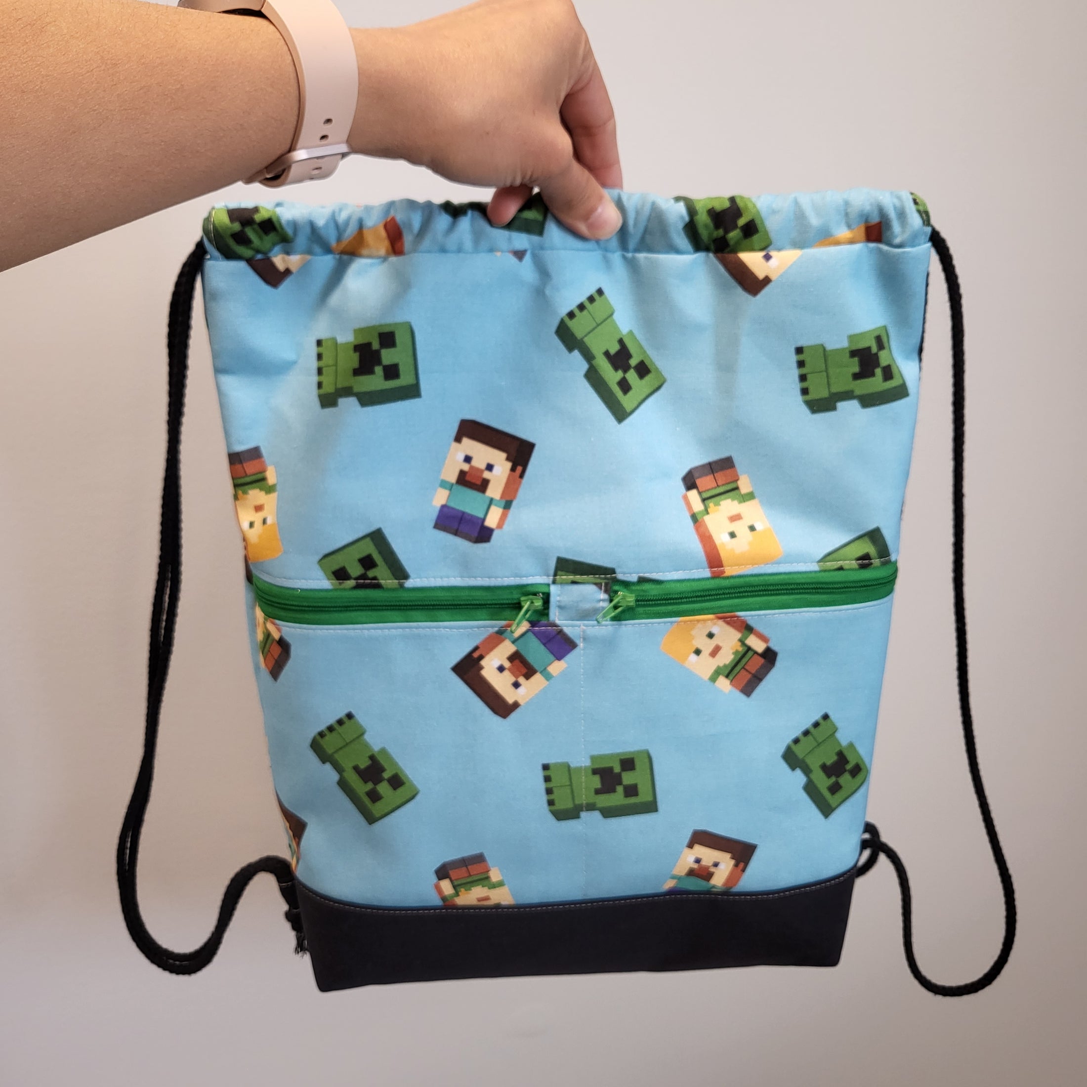 Front of the Minecraft themed drawstring backpack showing the 2 exterior zipper pockets. 