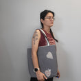 Load image into Gallery viewer, Person wearing the quilted heart tote with appliqued hearts and handsewn buttons facing out. 

