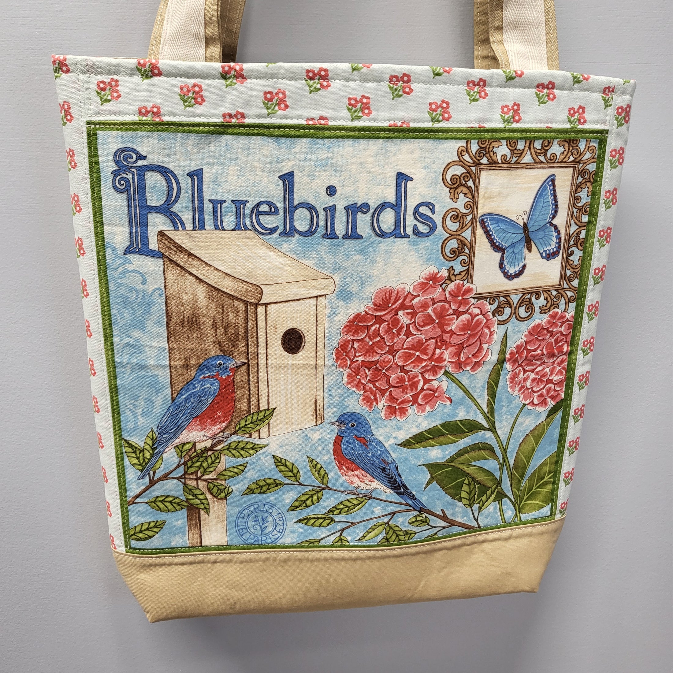 Bluebirds panel tote bag with tan bottom and tiny flowers on back. 