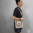 Load image into Gallery viewer, Person wearing the musical lady purse on a shoulder. 
