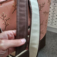 Load image into Gallery viewer, Brown and cream straps on the cherry blossom tote bag. 
